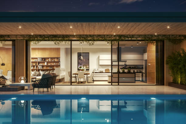 Luxury villa with swimming pool and patio furnitures at night.